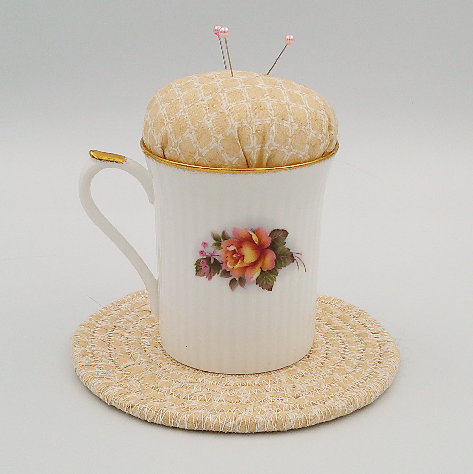 This is the back of the teacup showing different flowers and sitting on the trivet. This is the back of the teacup showing different flowers and sitting on the trivet.